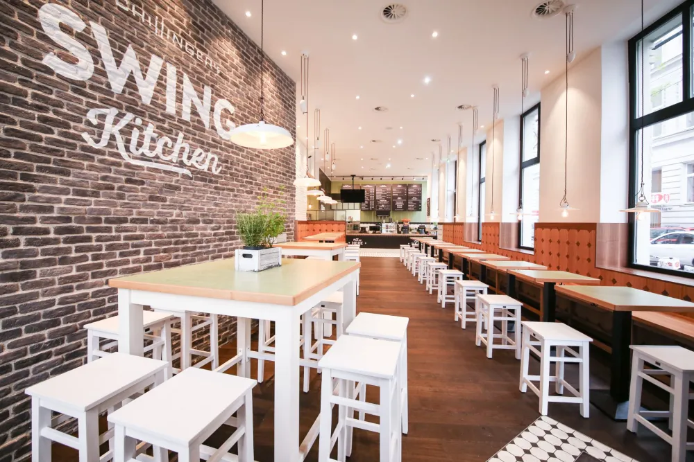 09-Swing-Kitchen-Restaurant-Gastraum-Hochsitzbereich-Ziegelwand-Derenko-Innendesign-Gastronomie.jpg